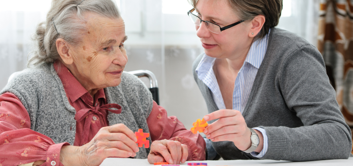 Eine Frau puzzelt mit einer alten Frau 