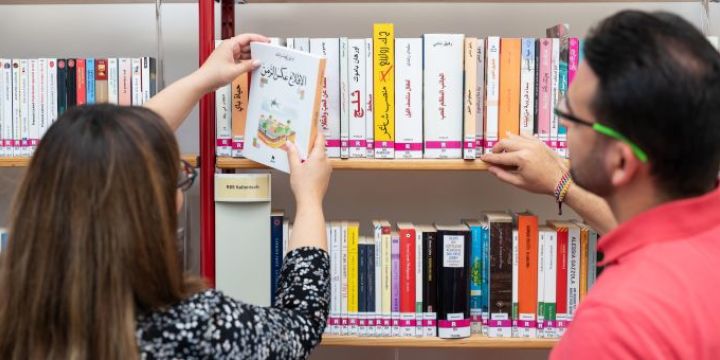 Ein Mann und eine Frau stehen vor Büchern mit arabischen Titeln Ernst-Abbe-Bücherei Jena