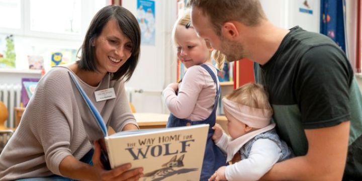 Lektorin liest einer Familie aus Buch vor in der Bibliothek Jena  ©JenaKultur | C. Worsch