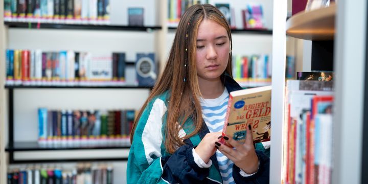 Junge Frau steht an einem Regal in der Bücherei Jena   ©JenaKultur | C. Worsch