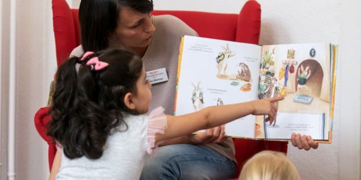 Frau liest zwei Kindern vor