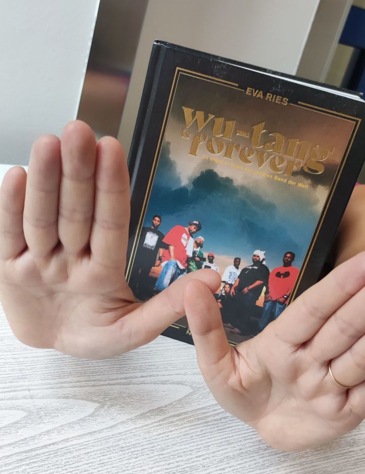 Buchcover von WuTang is forever und zwei Hände davor die ein w zeigen