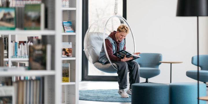Junge liest in einem Bubble-Chair ein Buch in der EAB  &copy;EAB | Christoph Worsch
