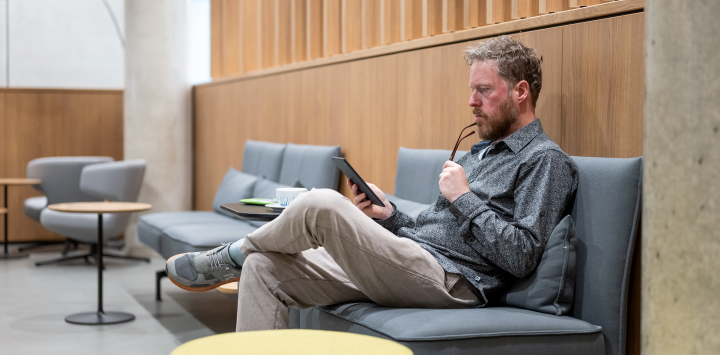 Mann sitzt lesend im Zeitschriftensalon EAB