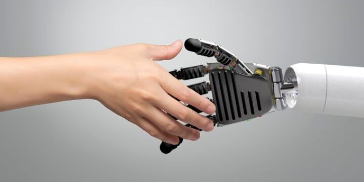 Eine menschliche Hand ist auf dem Weg einer Roboterhand die Hand zu geben.  ©Canva