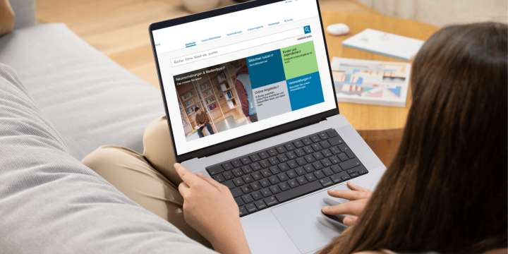 Frau sitz auf dem Sofa mit einem Laptop auf dem Schoß