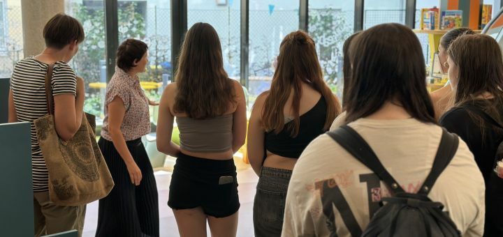 Bibliotheksmitarbeiterin zeigt Jugendlichen den Kinderbereich