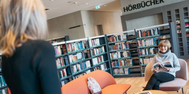 Eine Frau sitzt auf einem Sofa im Beletristikbereich ind er EAB  ©EAB|Christoph Worsch