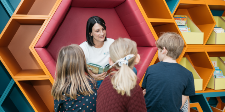 Eine Frau ließt drei Kindern ein Buch vor.  ©JenaKultur/EAB