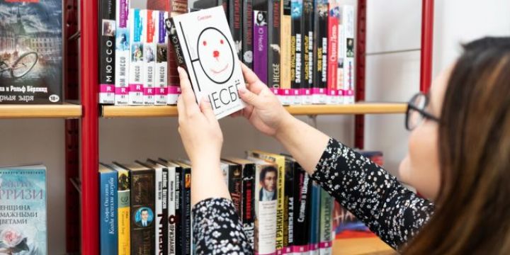 Frau hält ein Buch in russischer Sprache in der Hand Ernst-Abbe-Bücherei Jena   ©JenaKultur | C. Worsch