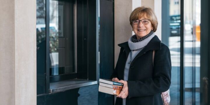 Eine Ältere Frau hält Bücher in der Hand und lächelt in die Kamera  ©EAB|Christoph Worsch