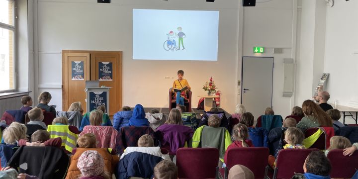 Autorin liest Kindern vor und zeigt Bild an einer Leinwand  ©EAB 