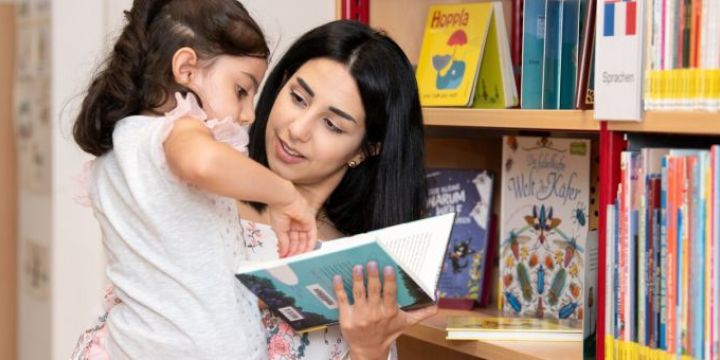 Mutter und Kind schauen sich ein Buch an Ernst-Abbe-Bücherei Jena   ©JenaKultur | C. Worsch