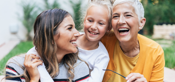 Eine Mädchen, ihre Mutter und ihre Oma umarmen sich