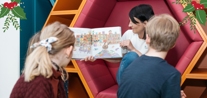 Eine Frau zeigt Kindern ein Buch