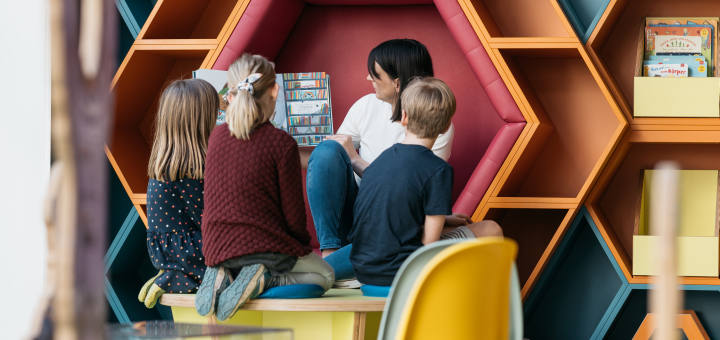 Frau liest Kindern ein Buch vor